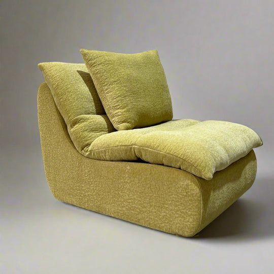 A beige NestFlex Modular Sofa with two pillows on top, presented in a minimalistic style.